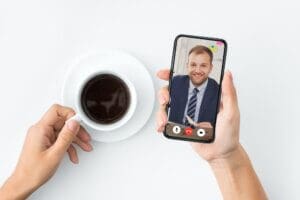 Businesswoman Making Video Call On Smartphone Talking With Coworker Indoor